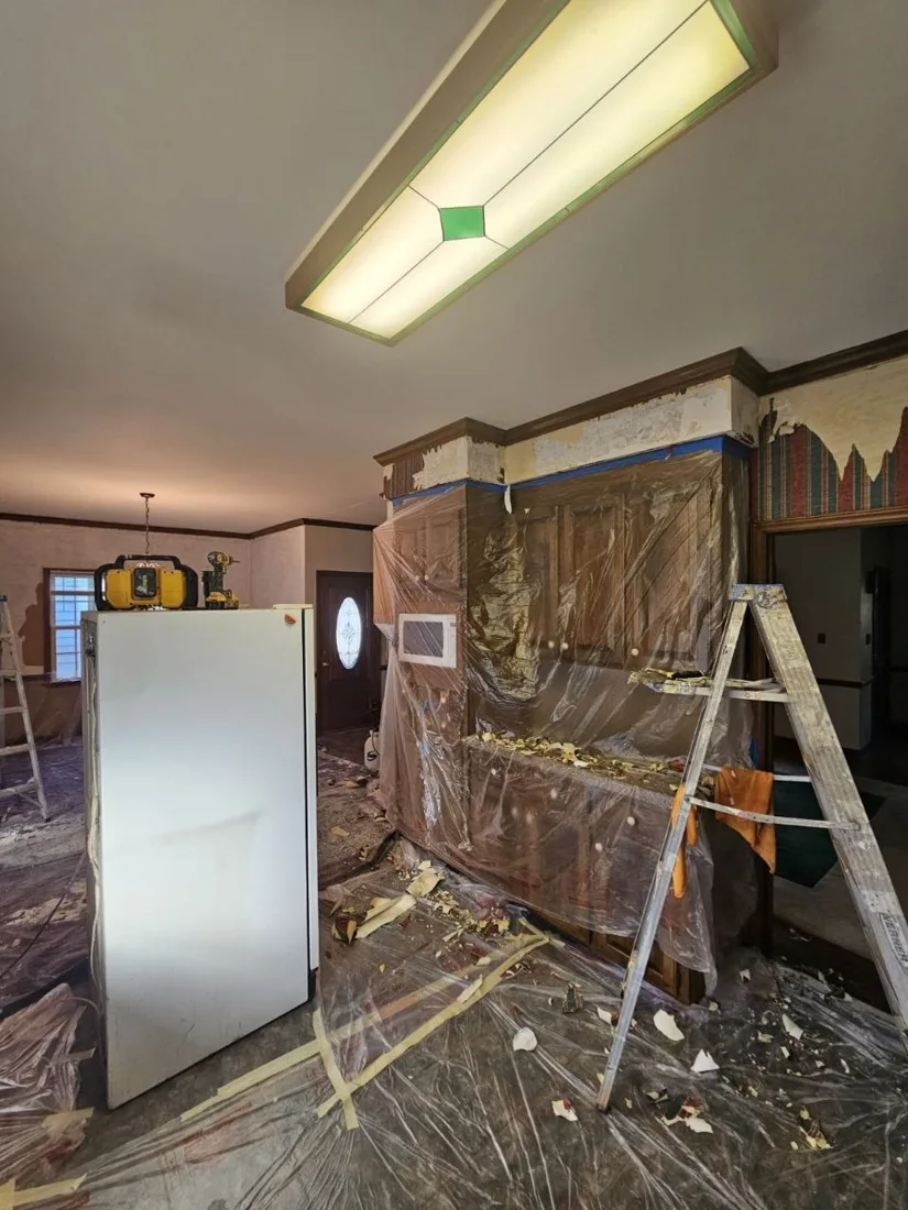 Kitchen walls during wallpaper removal with protected surfaces