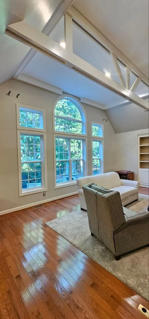Finished living space with large windows and wood flooring