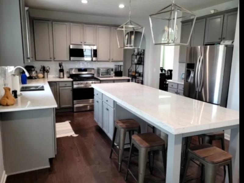 Kitchen with gray cabinets, island and stone countertops